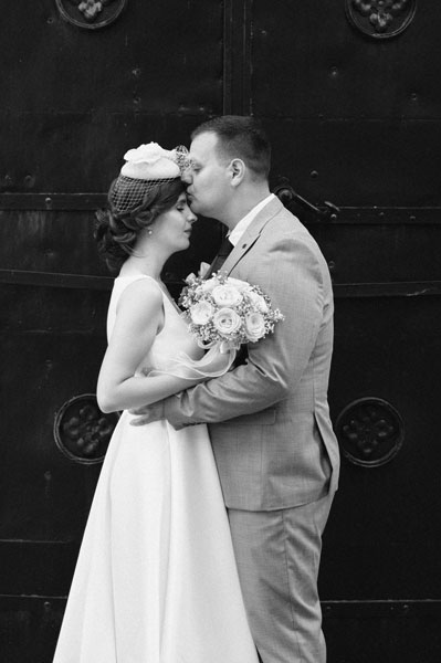 Mladoženja nježno ljubi u čelo mladu na dan njihovog vjenčanja u Beogradu.